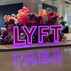 Balloons behind the Lyft logo at the Official opening of the Tech Office.